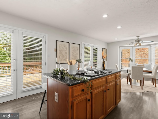 2828 Quarry Heights Way, Baltimore, MD 21209 - kitchen with black electric cooktop, dark wood finished floors, ceiling fan, dark countertops, and a breakfast bar