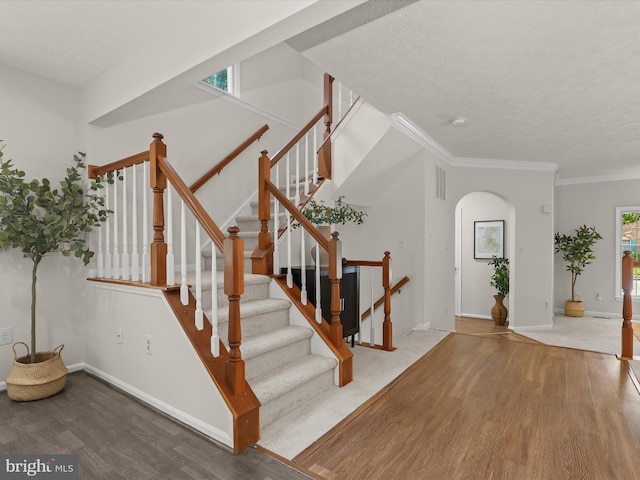 2828 Quarry Heights Way, Baltimore, MD 21209 - staircase with wood finished floors, a textured ceiling, arched walkways, crown molding, and baseboards