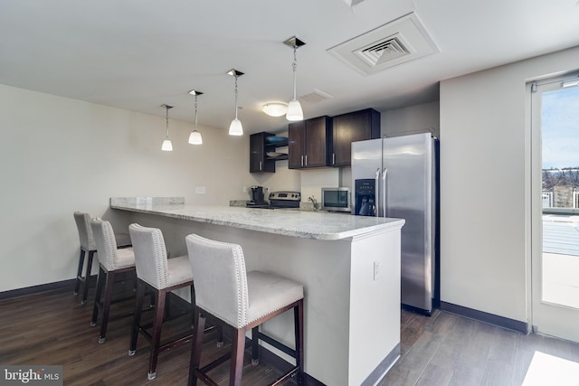 6301 Edsall Rd Unit 303, Alexandria, VA 22312 - kitchen featuring a peninsula, dark wood finished floors, visible vents, a kitchen bar, and appliances with stainless steel finishes
