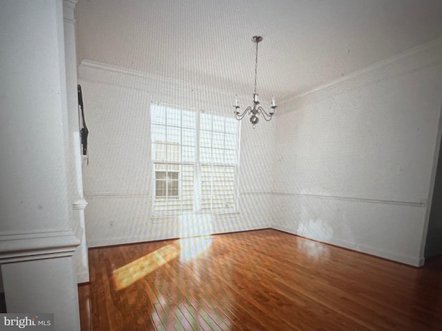 unfurnished dining area with hardwood / wood-style flooring, baseboards, and an inviting chandelier