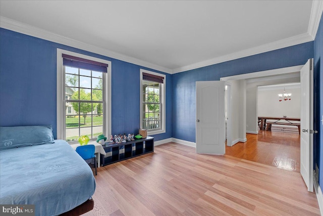 bedroom featuring an inviting chandelier, baseboards, ornamental molding, and light wood-style flooring