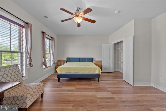 bedroom with visible vents, a ceiling fan, baseboards, and light wood-type flooring