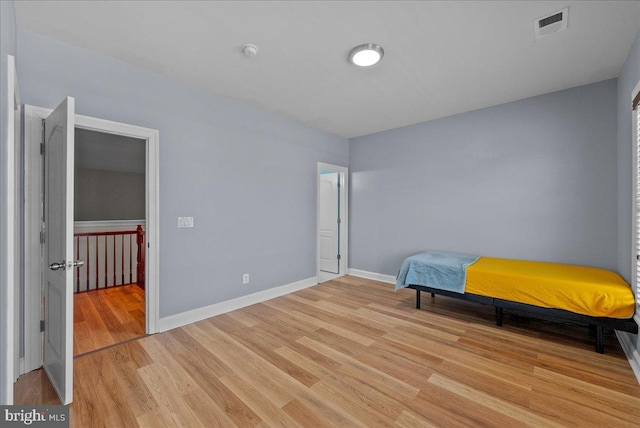 bedroom featuring baseboards, visible vents, and light wood-type flooring