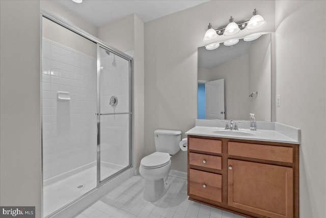 bathroom with vanity, toilet, baseboards, tile patterned floors, and a shower stall