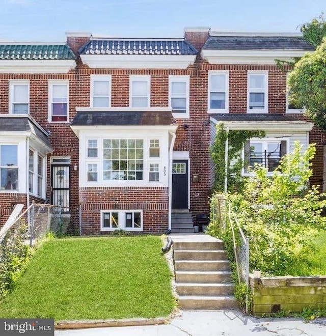 805 Cator Ave, Baltimore, MD 21218 - view of front of home with brick siding, a tile roof, and a front yard