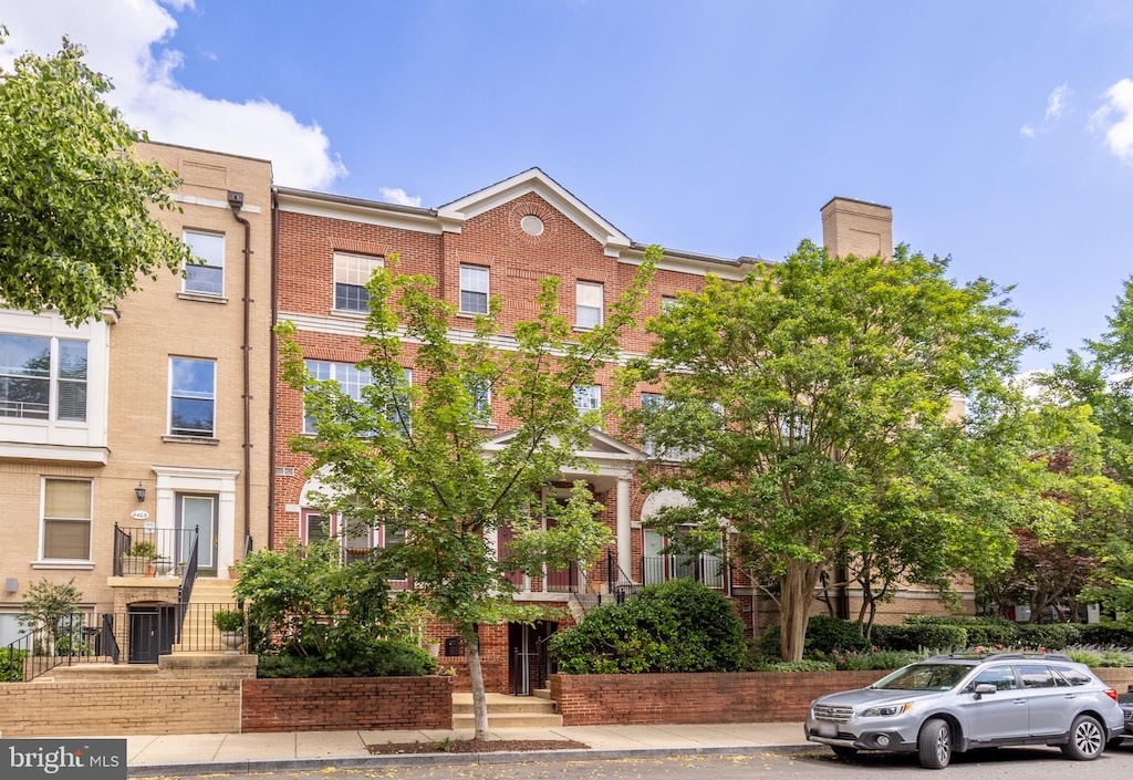 multi unit property featuring brick siding and a chimney