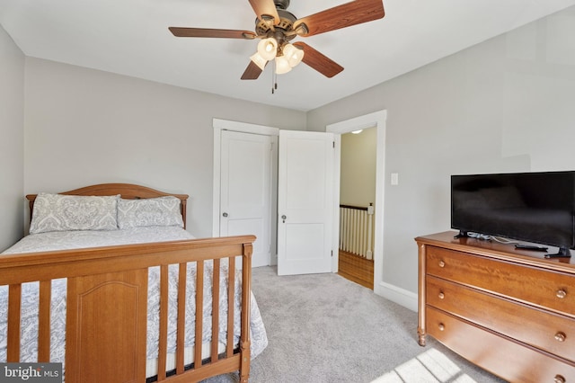 bedroom featuring baseboards, ceiling fan, and light carpet