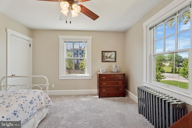 bedroom with radiator, multiple windows, and carpet floors