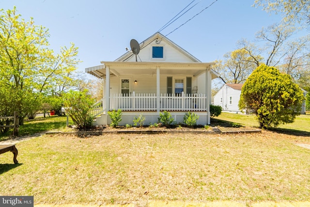 bungalow with covered porch and a front lawn