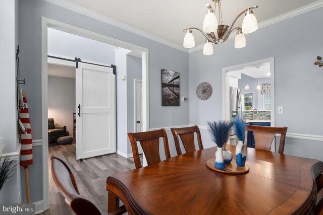 362 Hoffeckers Mill Dr, Smyrna, DE 19977 - dining space with a chandelier, wood finished floors, a barn door, crown molding, and baseboards