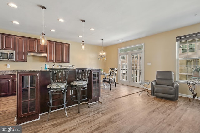 kitchen with recessed lighting, light wood finished floors, stainless steel microwave, and a healthy amount of sunlight