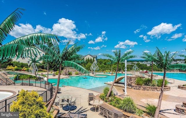 pool featuring fence and a patio area