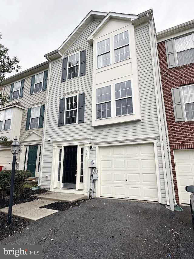 multi unit property featuring aphalt driveway and a garage