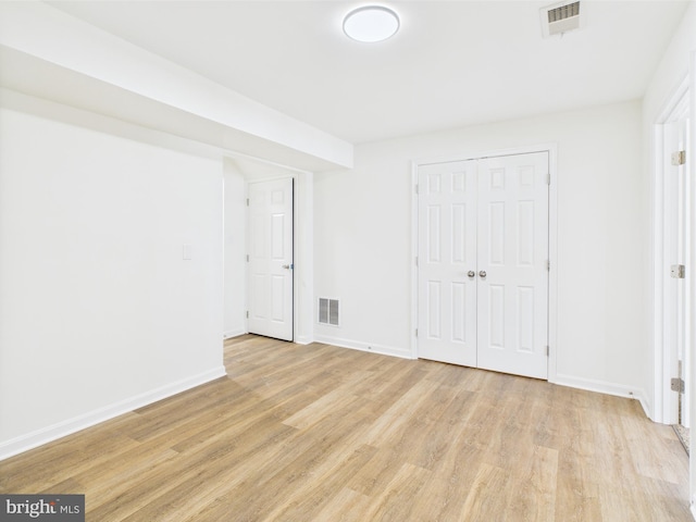 unfurnished bedroom featuring baseboards, light wood finished floors, and visible vents