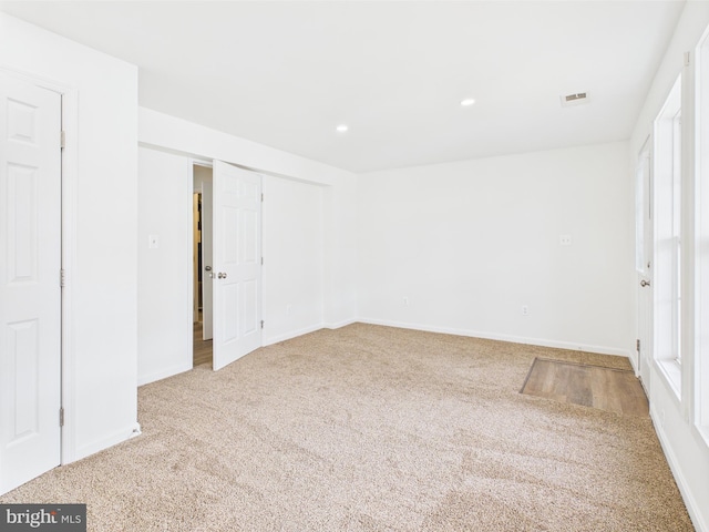 spare room featuring baseboards, carpet flooring, visible vents, and recessed lighting