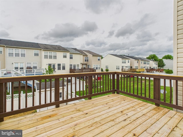 wooden deck with a yard and a residential view