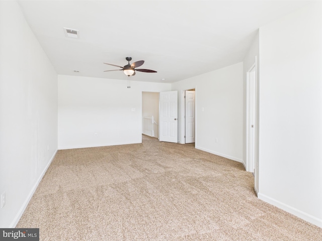 spare room with ceiling fan, carpet flooring, baseboards, and visible vents