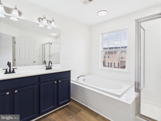 full bath featuring a garden tub, wood finished floors, a shower stall, and a sink