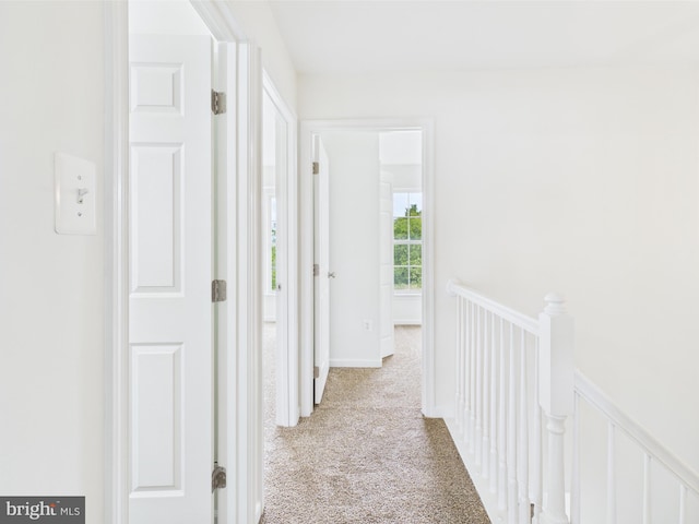 hallway featuring carpet and an upstairs landing