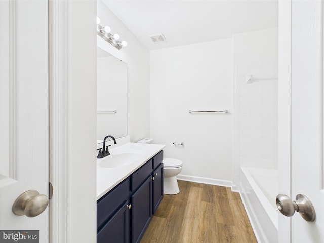 full bath featuring a bathtub, toilet, baseboards, vanity, and wood finished floors