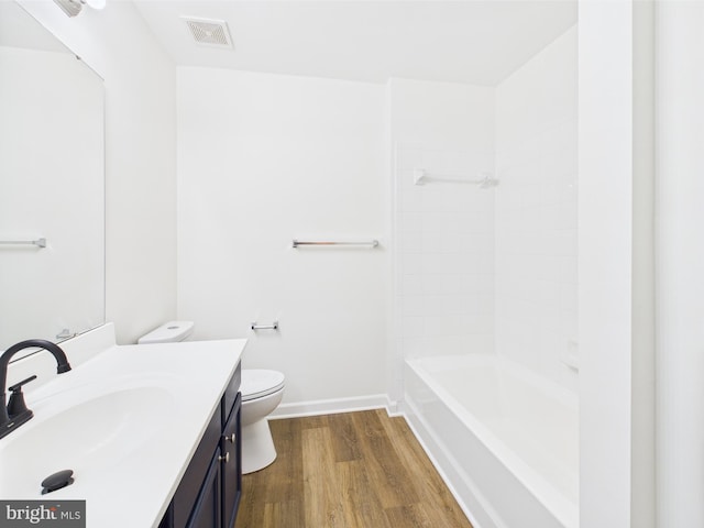 bathroom featuring toilet, wood finished floors, visible vents, baseboards, and vanity