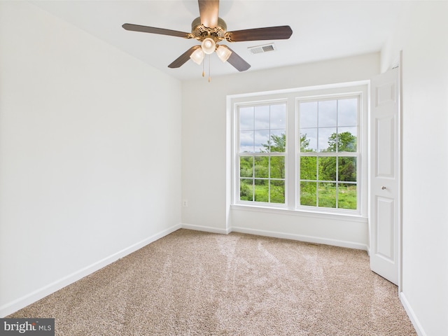 unfurnished room with carpet, visible vents, baseboards, and ceiling fan