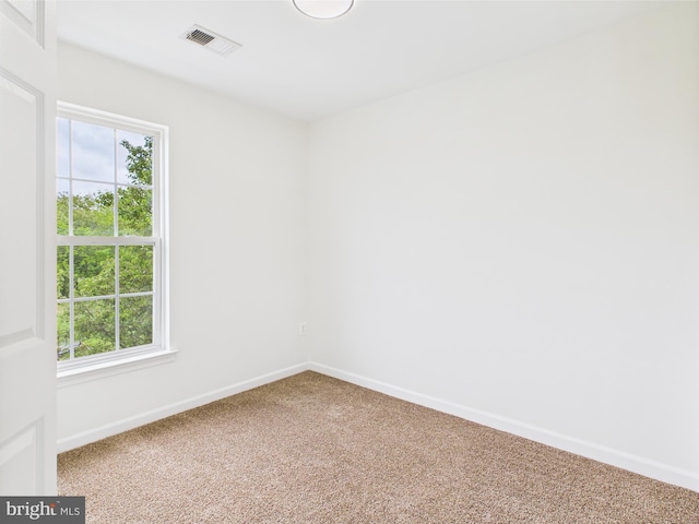 unfurnished room featuring carpet flooring, visible vents, baseboards, and a healthy amount of sunlight