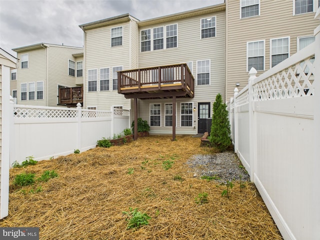 back of house featuring a wooden deck and a fenced backyard