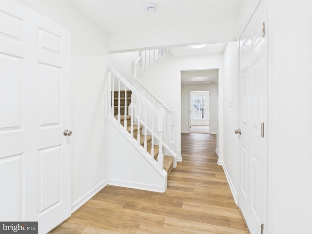stairway featuring baseboards and wood finished floors