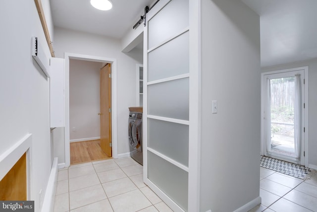 8604 Tobin Rd, Annandale, VA 22003 - washroom featuring washer / clothes dryer, a barn door, light tile patterned flooring, and baseboards