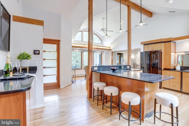 8604 Tobin Rd, Annandale, VA 22003 - kitchen featuring freestanding refrigerator, a sink, light wood-type flooring, a kitchen breakfast bar, and beam ceiling