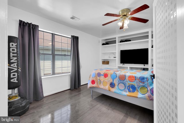 bedroom with baseboards, visible vents, wood finished floors, and ceiling fan