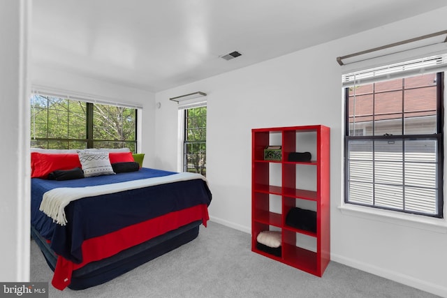carpeted bedroom with visible vents and baseboards