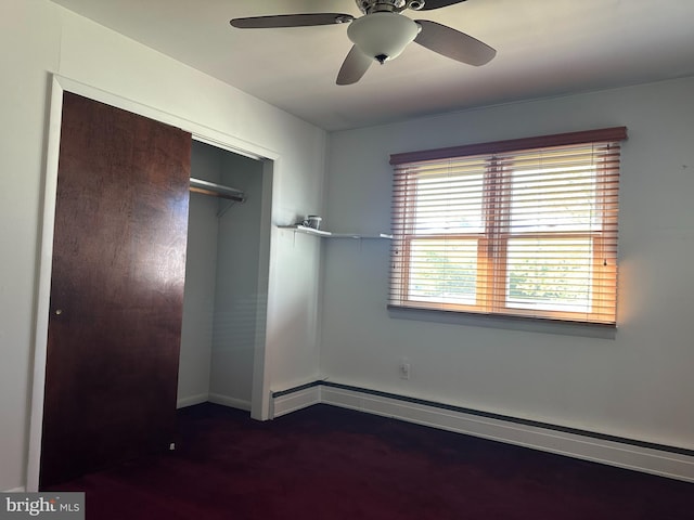 unfurnished bedroom with a closet, ceiling fan, dark carpet, baseboards, and baseboard heating