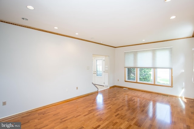 empty room with crown molding, baseboards, light wood-style floors, and recessed lighting