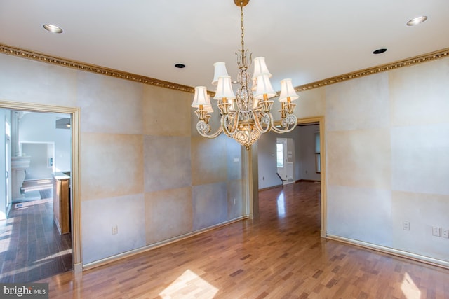 unfurnished dining area with recessed lighting, crown molding, wood finished floors, and a notable chandelier