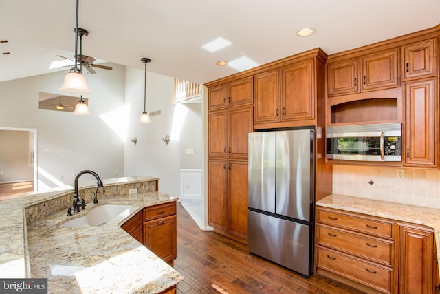 kitchen featuring a sink, appliances with stainless steel finishes, brown cabinets, and dark wood-style floors