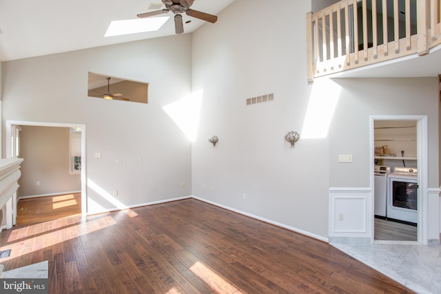 unfurnished living room featuring a skylight, high vaulted ceiling, ceiling fan, and visible vents