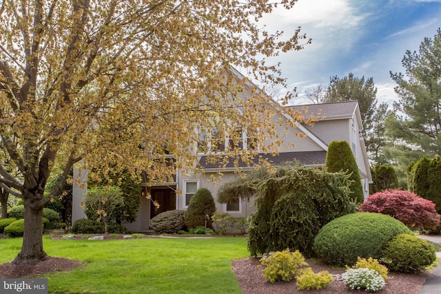 view of front of house featuring stucco siding and a front yard