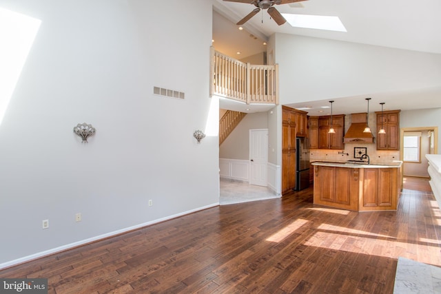 kitchen featuring visible vents, wood finished floors, ceiling fan, premium range hood, and light countertops