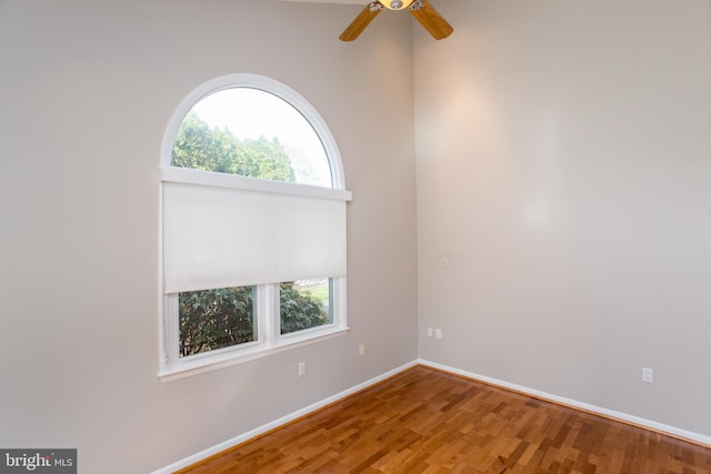 spare room featuring a ceiling fan, baseboards, and wood finished floors