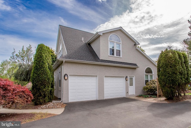 view of property exterior with driveway, a shingled roof, and stucco siding