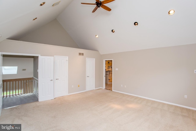 interior space with high vaulted ceiling, visible vents, light carpet, and baseboards