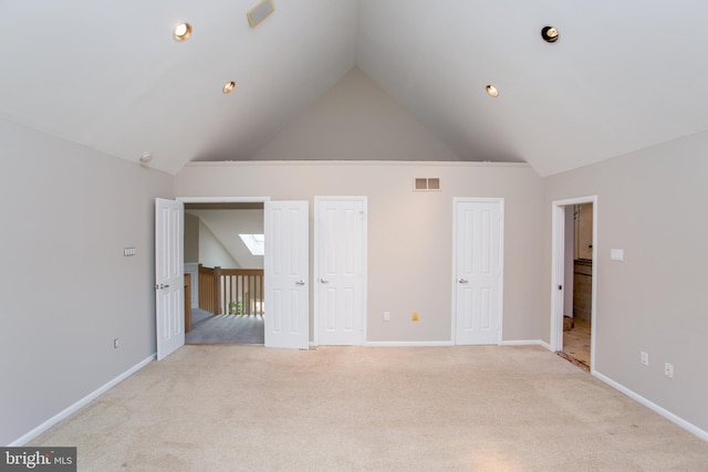 unfurnished bedroom with two closets, light colored carpet, high vaulted ceiling, and visible vents