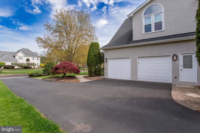 view of home's exterior featuring a garage, aphalt driveway, and stucco siding