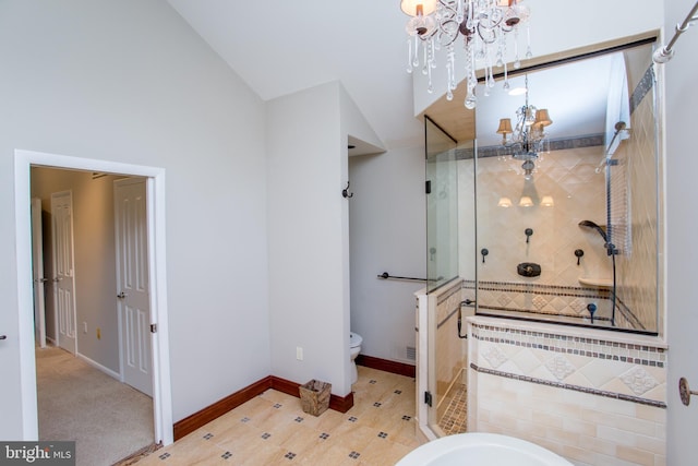 bathroom with toilet, a chandelier, baseboards, vaulted ceiling, and a stall shower