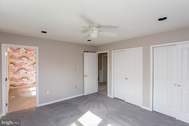 unfurnished bedroom with carpet floors, multiple closets, baseboards, and visible vents
