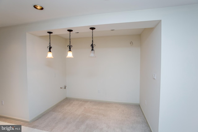 spare room featuring light colored carpet and baseboards