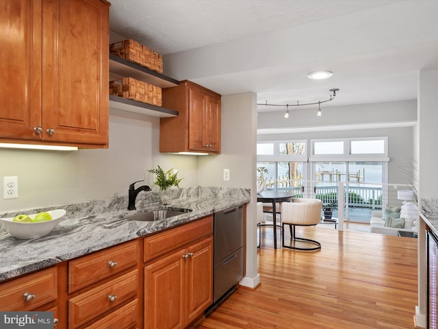 504 Moorings Cir, Arnold, MD 21012 - kitchen with light stone countertops, stainless steel dishwasher, brown cabinetry, a sink, and light wood-type flooring
