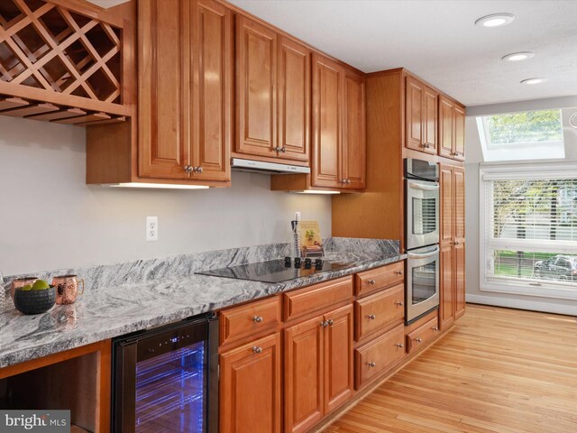 504 Moorings Cir, Arnold, MD 21012 - kitchen featuring beverage cooler, stainless steel double oven, light wood-style floors, under cabinet range hood, and black electric cooktop
